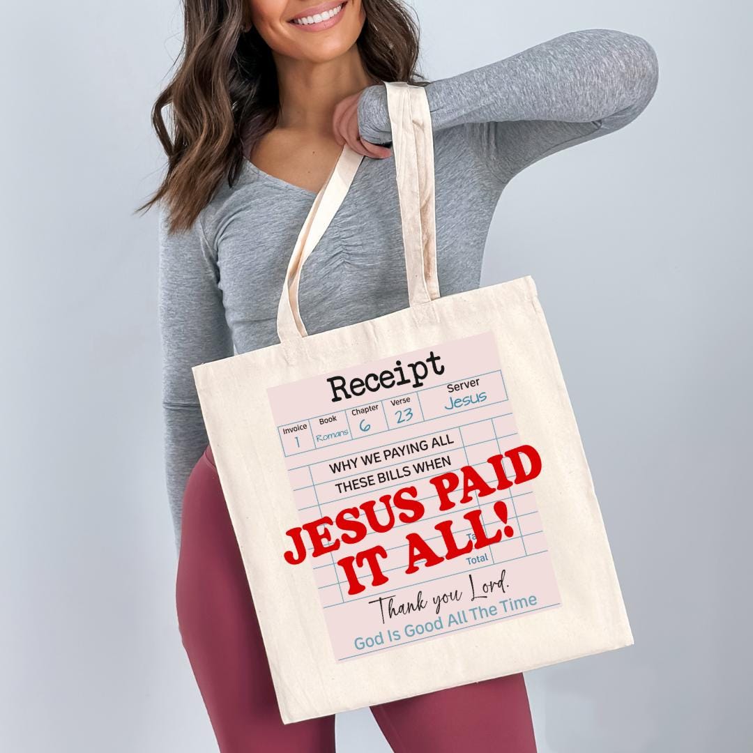 A woman is holding a white tote bag with a humorous text printed on it.