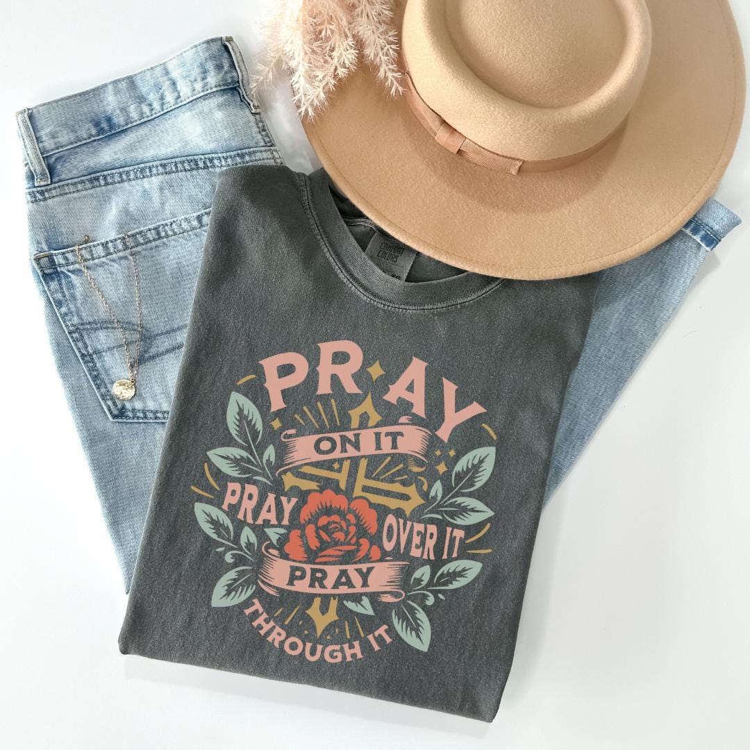 a hat, jeans, and a t - shirt on a white surface