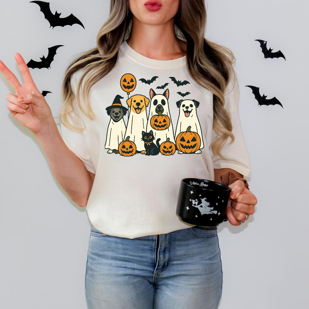 A woman is holding a mug with a Halloween-themed design featuring dogs and pumpkins, while making a peace sign with her hand.