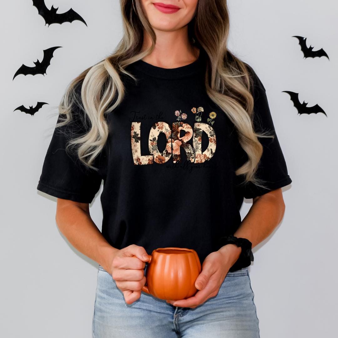 A woman with long blonde hair is holding a pumpkin-shaped mug in front of her.