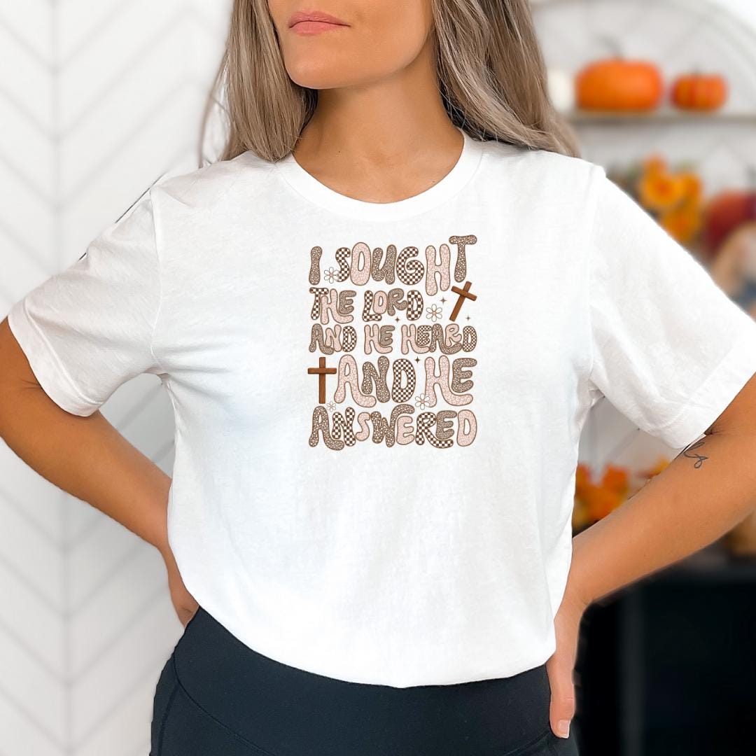 A woman wearing a white t-shirt with a printed text design on it.