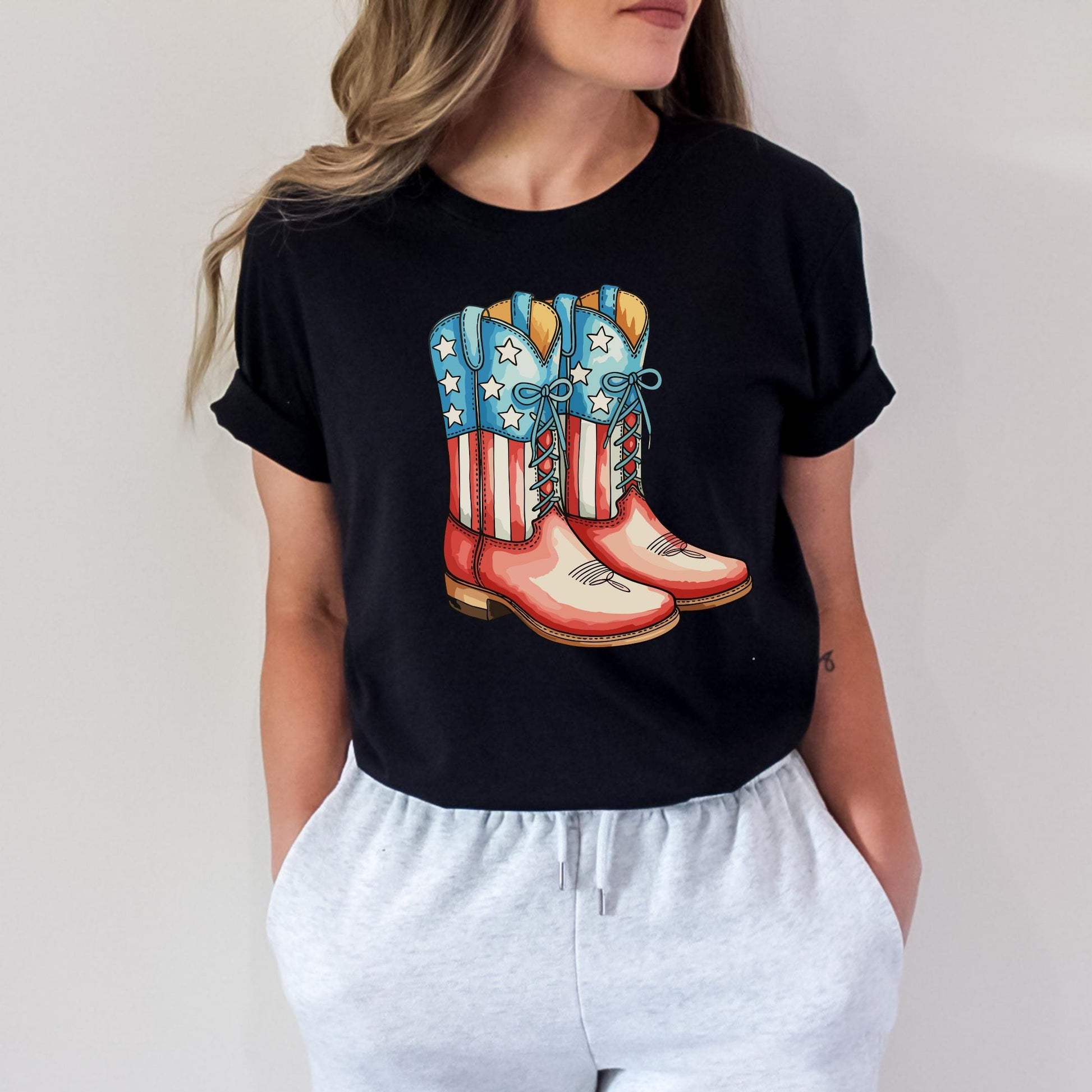 A woman wearing a black t-shirt with a graphic of red, white, and blue cowboy boots printed on it.