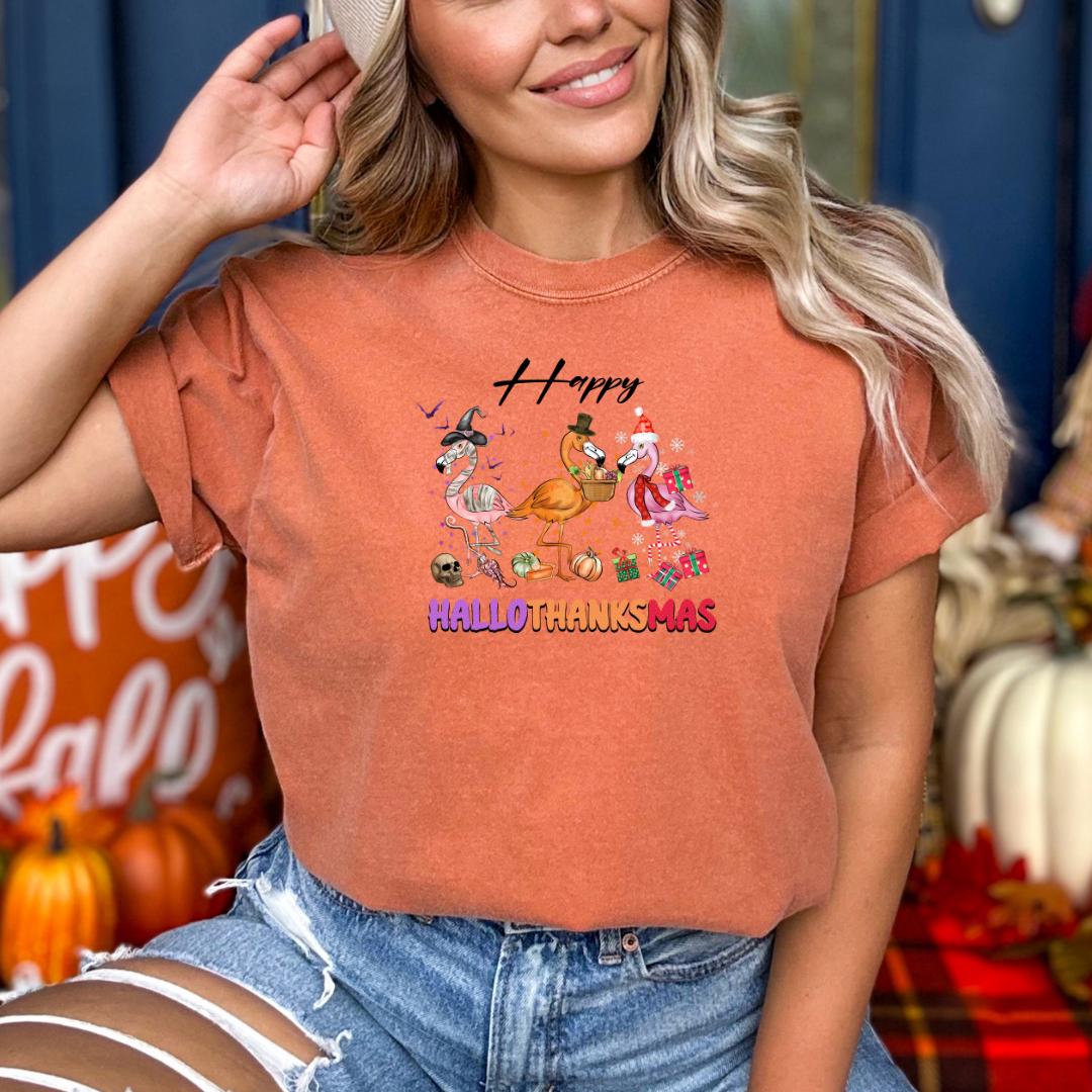 A woman wearing a t-shirt with a graphic design of cartoon characters and text, smiling and posing in front of a background with pumpkins and other fall decorations.
