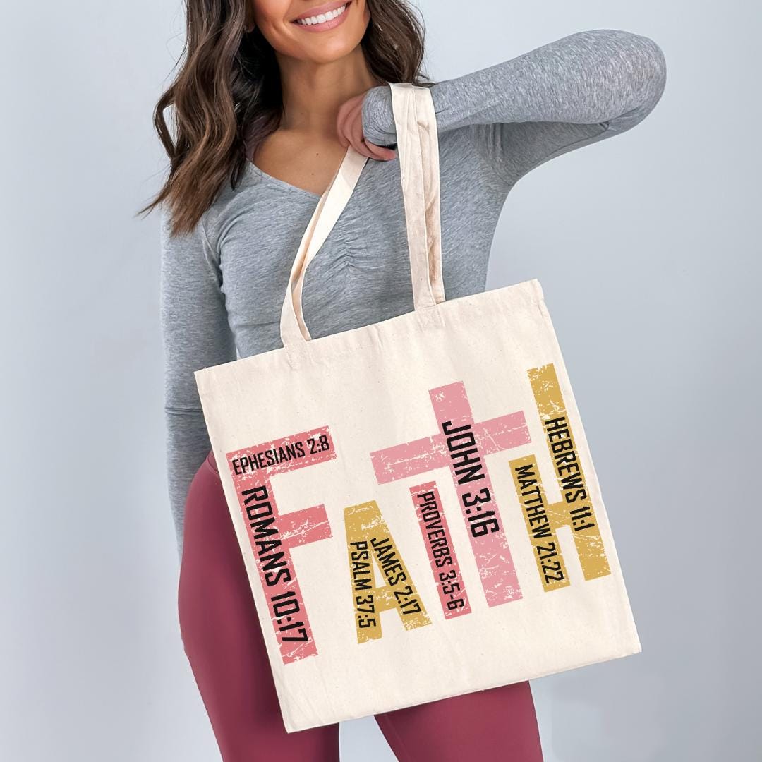 A woman is holding a large tote bag with printed text and Bible verse references.