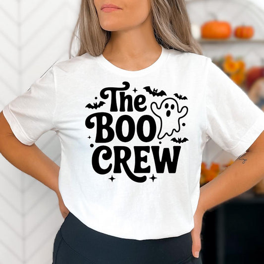 A woman wearing a white t-shirt with the text "The Boo Crew" printed on it.