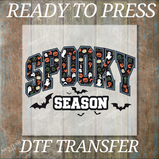 The image is a Halloween-themed graphic with the word "SPOOKY" and the word "SEASON" prominently displayed. The graphic includes various Halloween-related elements such as bats, pumpkins, and ghostly figures. The image is described as a "DTF TRANSFER" and "READY TO PRESS", indicating that it is a digital transfer of the graphic design.