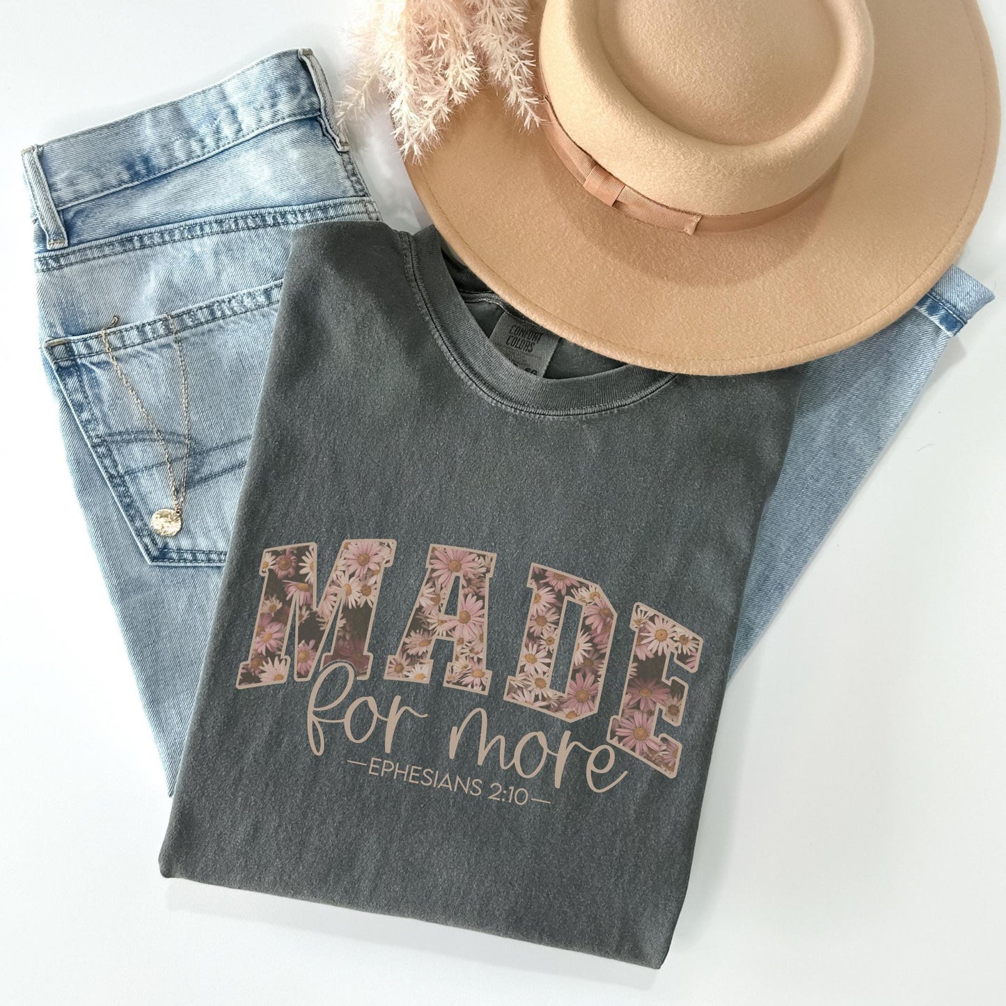 a hat, jeans, and a t - shirt on a white surface