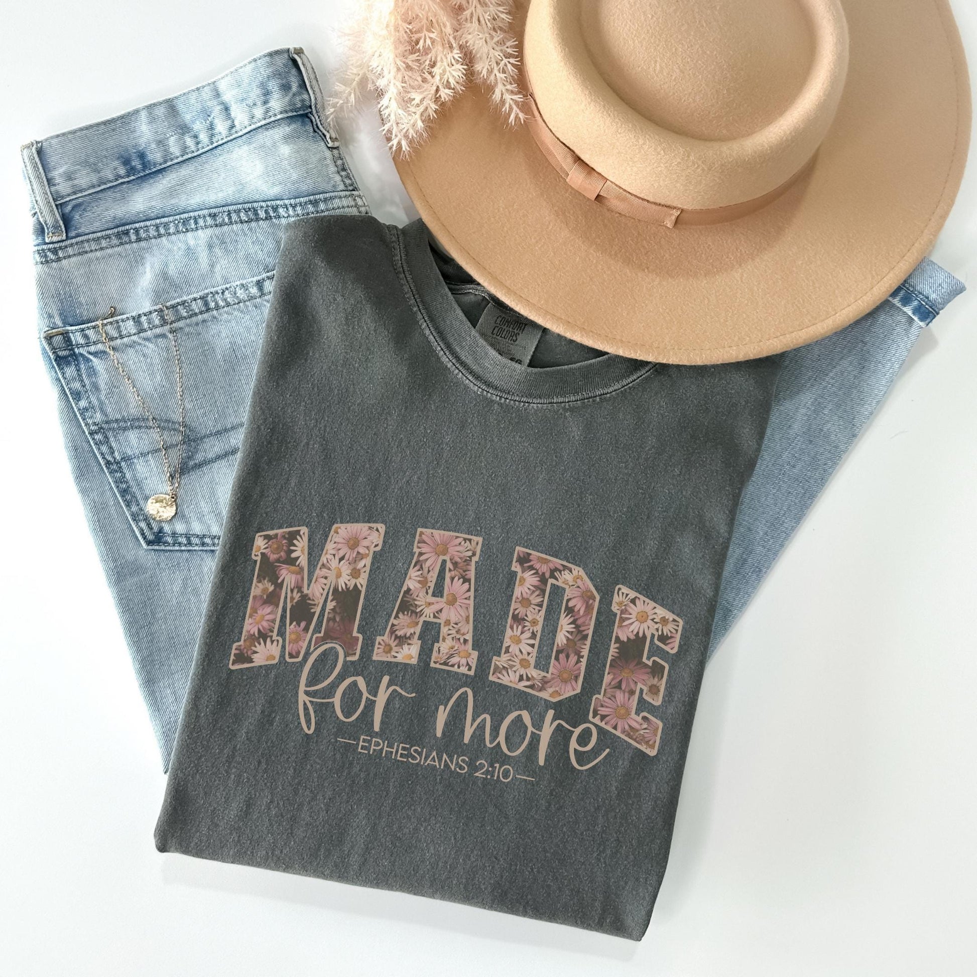 a hat, jeans, and a t - shirt on a white surface