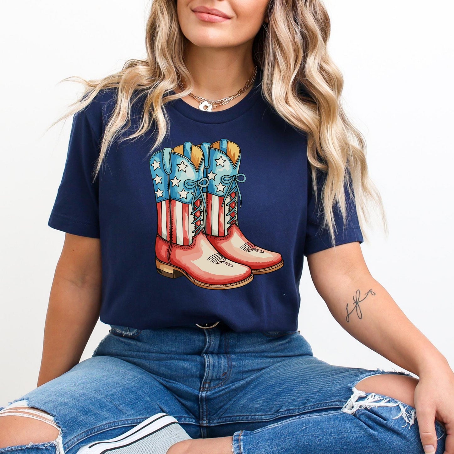 A woman wearing a navy blue t-shirt with a graphic of red and white cowboy boots.