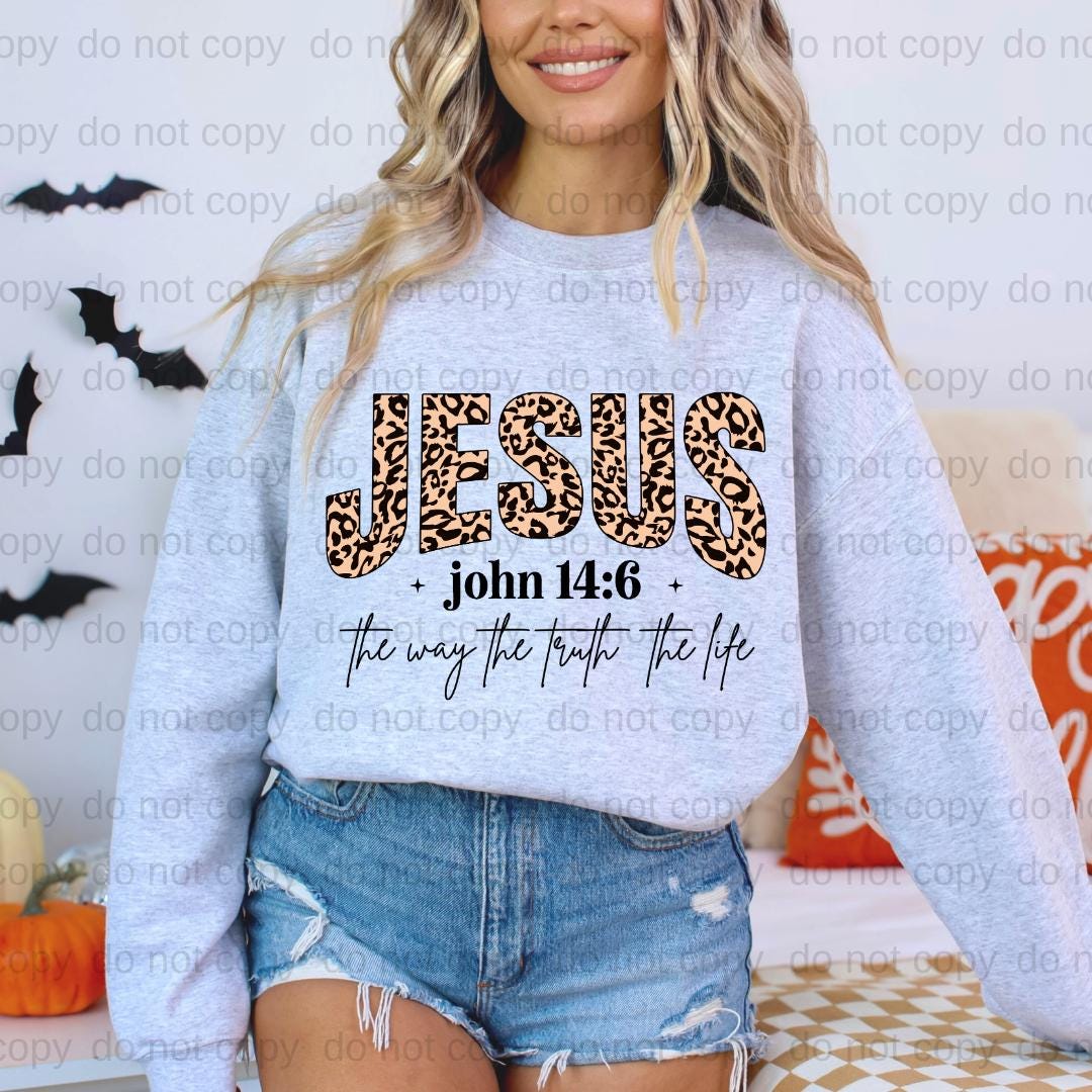 A woman wearing a grey sweatshirt with a leopard print design and text printed on it.