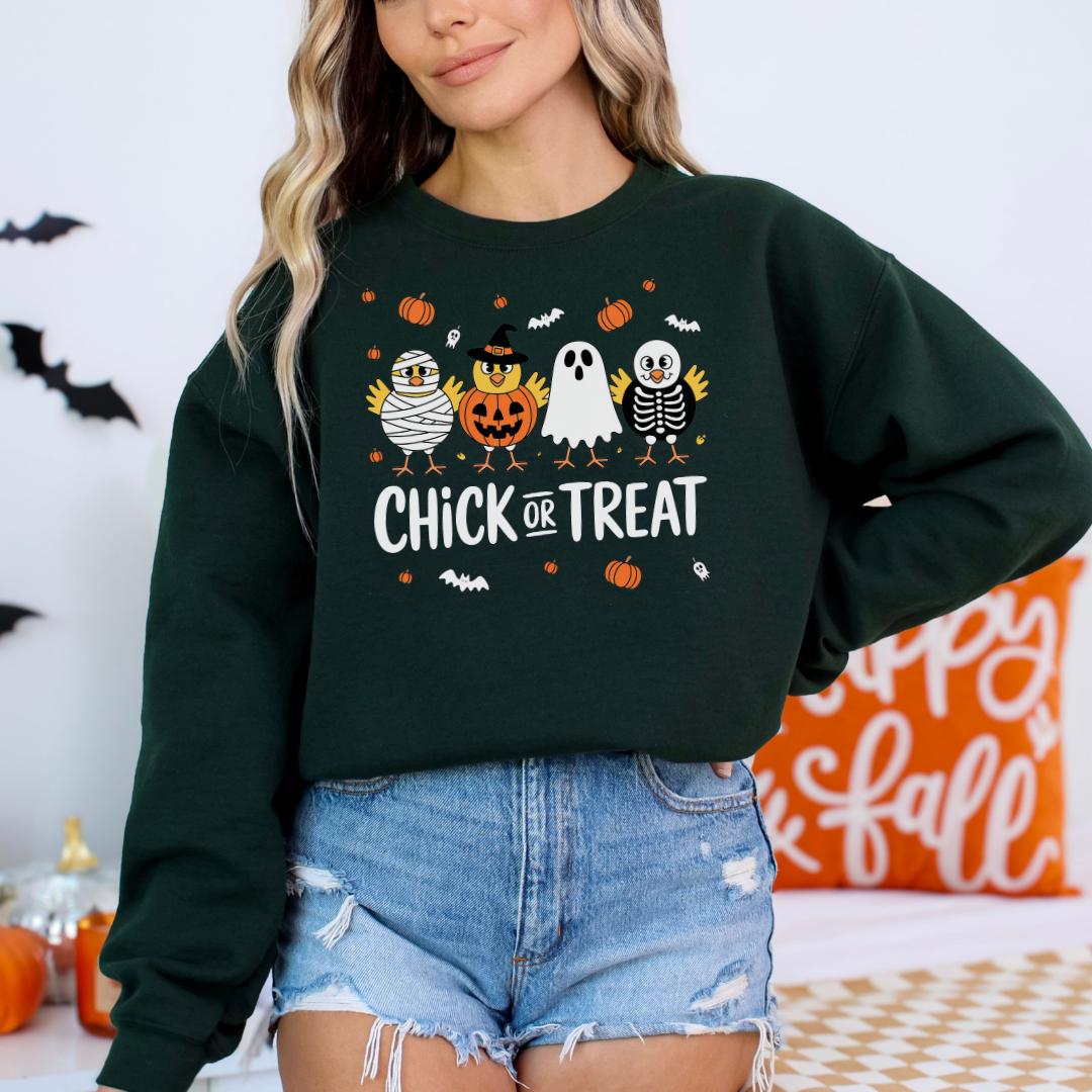 A woman wearing a green sweatshirt with a Halloween-themed design, including a pumpkin, ghost, and skeleton.