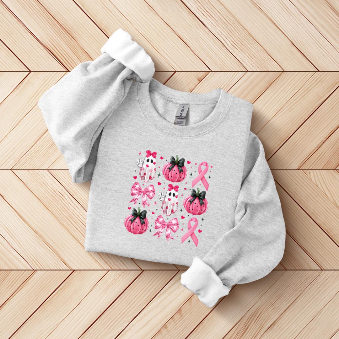 A gray sweatshirt with a pink and white design featuring pumpkins, bows, and a pink ribbon, which appears to be related to breast cancer awareness.