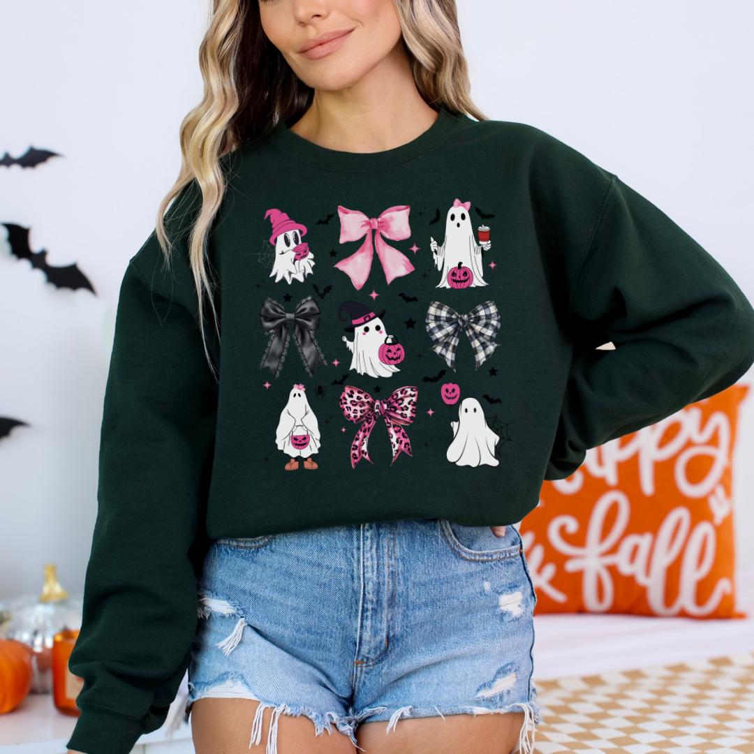 A woman wearing a green sweatshirt with a graphic design of various Halloween-themed ghost characters and accessories.